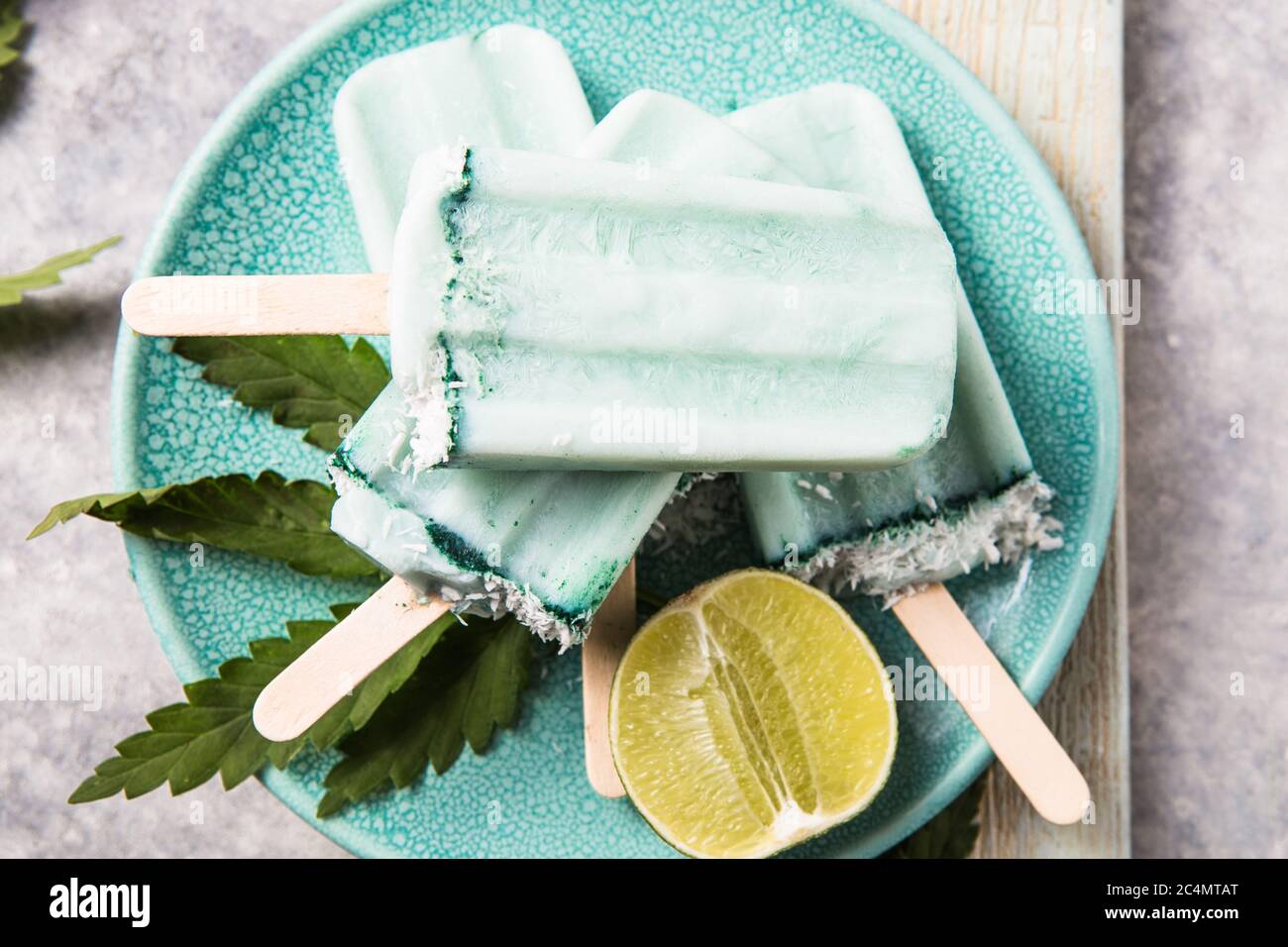 Eis-Eis-Eisdielen mit Kokosnussscheiben, Cannabis auf Betongrund. Stockfoto