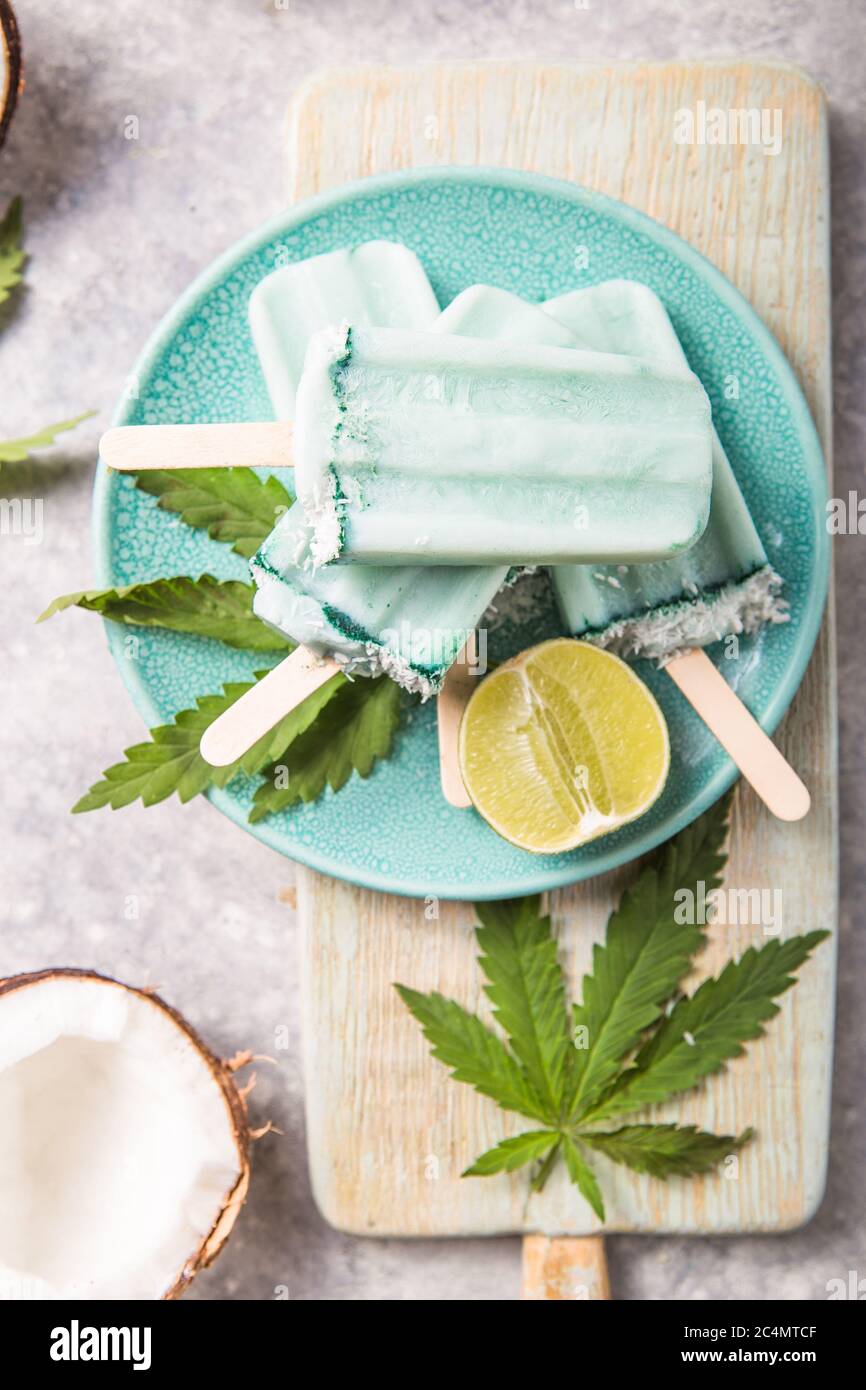 Eis-Eis-Eisdielen mit Kokosnussscheiben, Cannabis auf Betongrund. Stockfoto