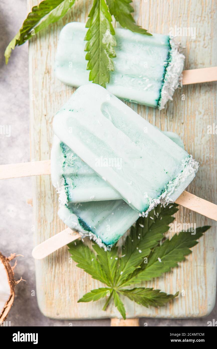 Eis-Eis-Eisdielen mit Kokosnussscheiben, Cannabis auf Betongrund. Stockfoto