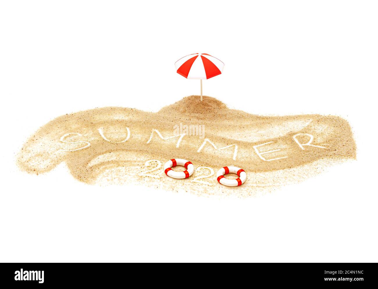 Text SOMMER 2020 geschrieben in Sand auf einem Miniaturstrand mit einem Spielzeug Sonnenschirm und Rettungsschwimmern. Sommerferien Konzept. Stockfoto