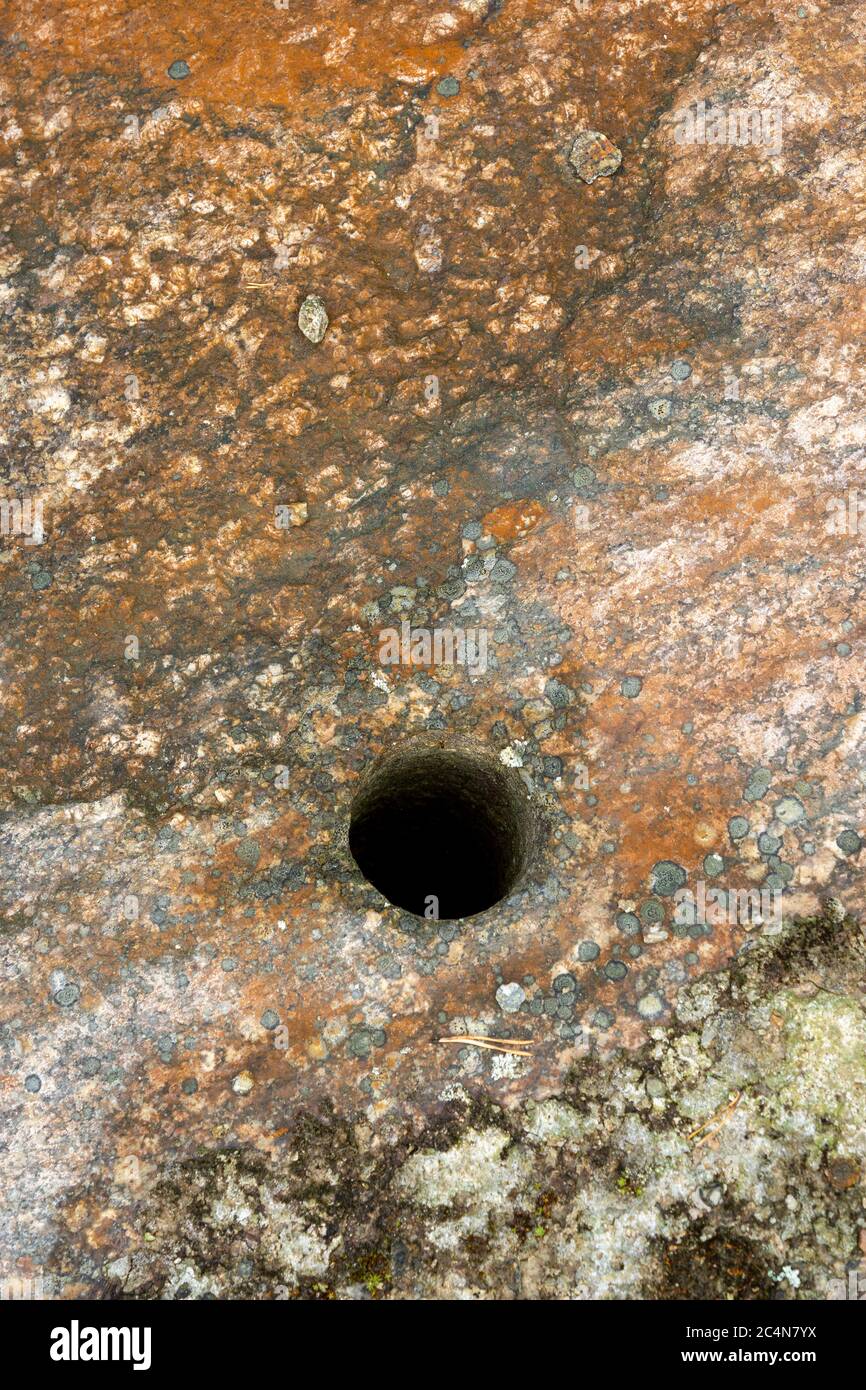 Nahaufnahme eines gebohrten Sprenglochs für Sprengstoffe im Gestein Stockfoto