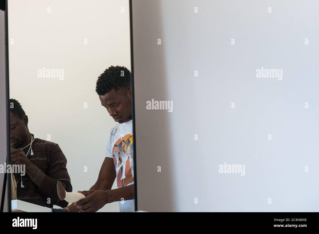 Politische Flüchtlinge und afrikanische Einwanderer arbeiten an der Schneiderei der gemeinnützigen Vereinigung im Süden Italiens, Neapel. Stockfoto