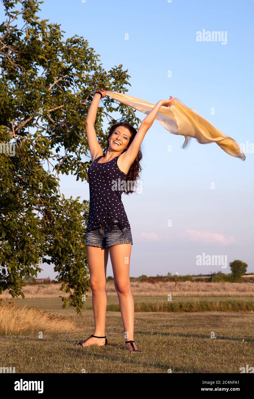 Glückliche Frau winkt ihren Schal im Wind Stockfoto