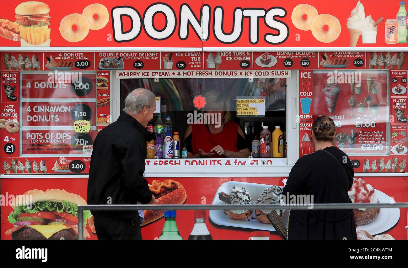 Die Öffentlichkeit kauft an einem Donuts-Stand in Skegness, da Regen-, Wind- und Wetterwarnungen die schwellende Juni-Hitzewelle beenden. Stockfoto