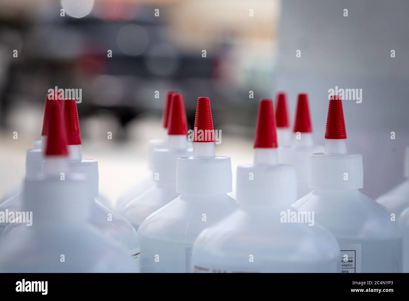 Flaschen mit lokal angebauter Hand-Desinfektionsmittel Nahaufnahme mit verschwommenem Hintergrund auf dem Parkplatz ausgeblasen Stockfoto