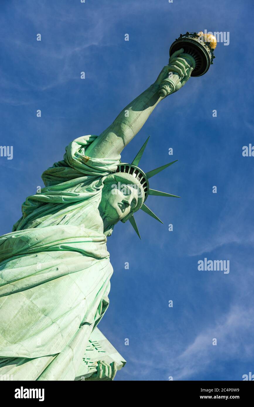 Nahaufnahme der Freiheitsstatue bei einem wolkigen blauen Himmel, New York City. Stockfoto