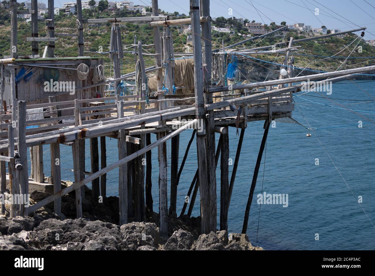 Typische traditionelle Fischerei trabucco auf Holzpfosten am Strand mit Felsen in der Nähe von Vieste in Italien. Stockfoto