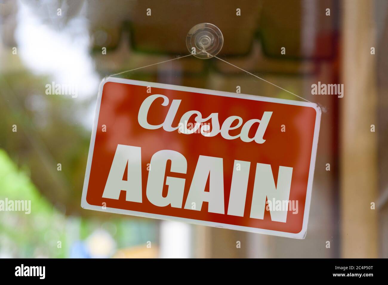 Nahaufnahme auf einem roten offenen Schild im Fenster eines Ladens mit der Meldung: Wieder geschlossen. Stockfoto