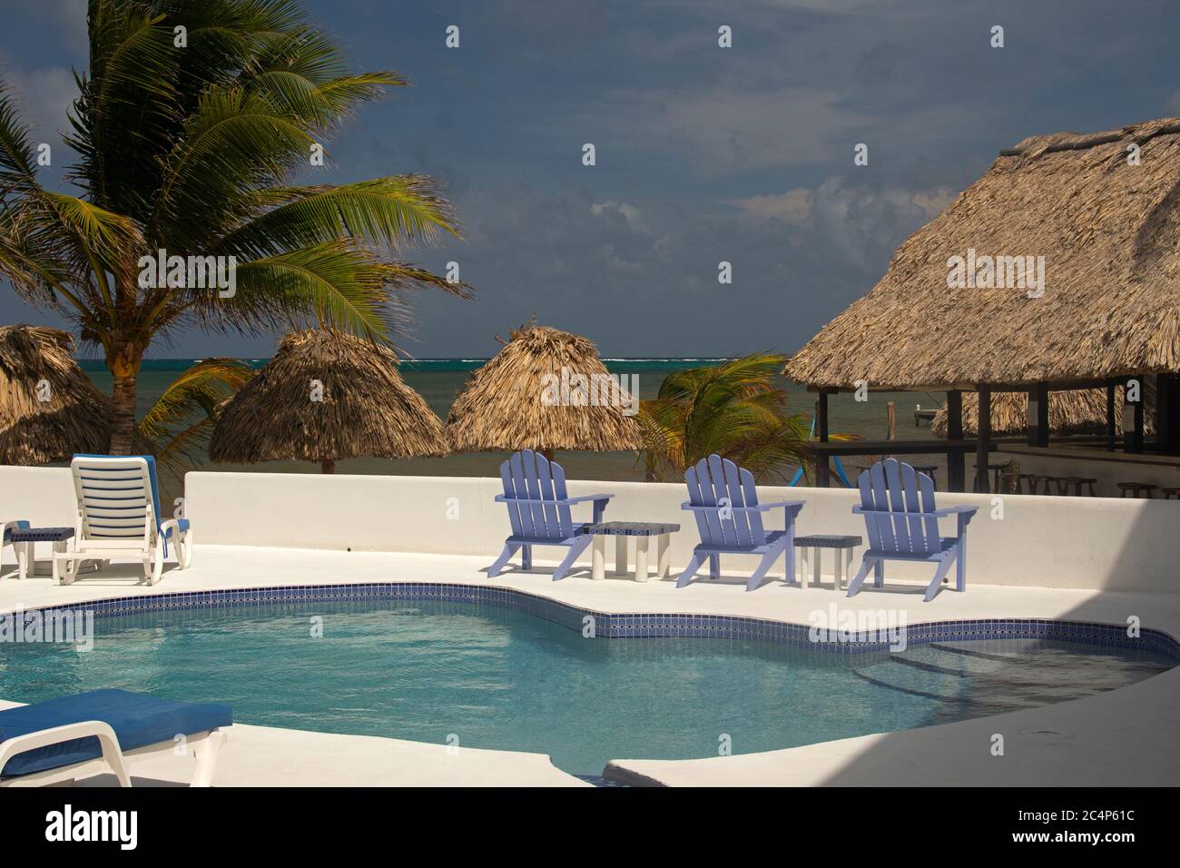 Strandliegen und Pool in einem Resort am Wasser, San Pedro, Ambergris Caye, Belize Stockfoto