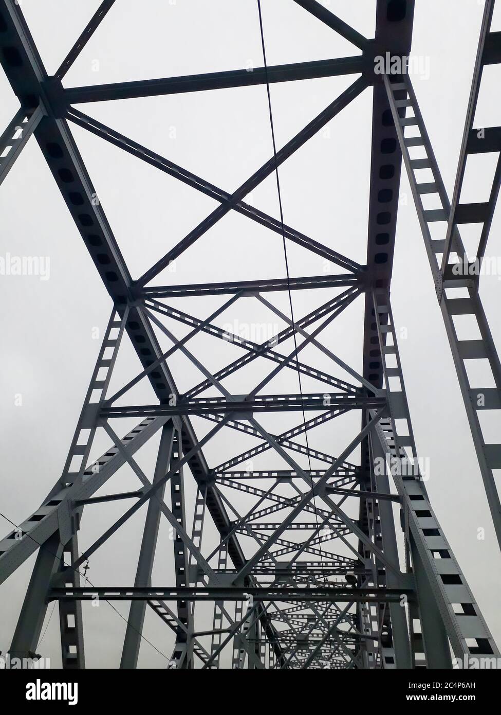 Metallkonstruktion der Eisenbahnbrücke mit dem aufsteigenden Mittelteil für die Durchfahrt von Schiffen. Blick von unten vom Fenster des Autos. Architektur, Designelemente Stockfoto