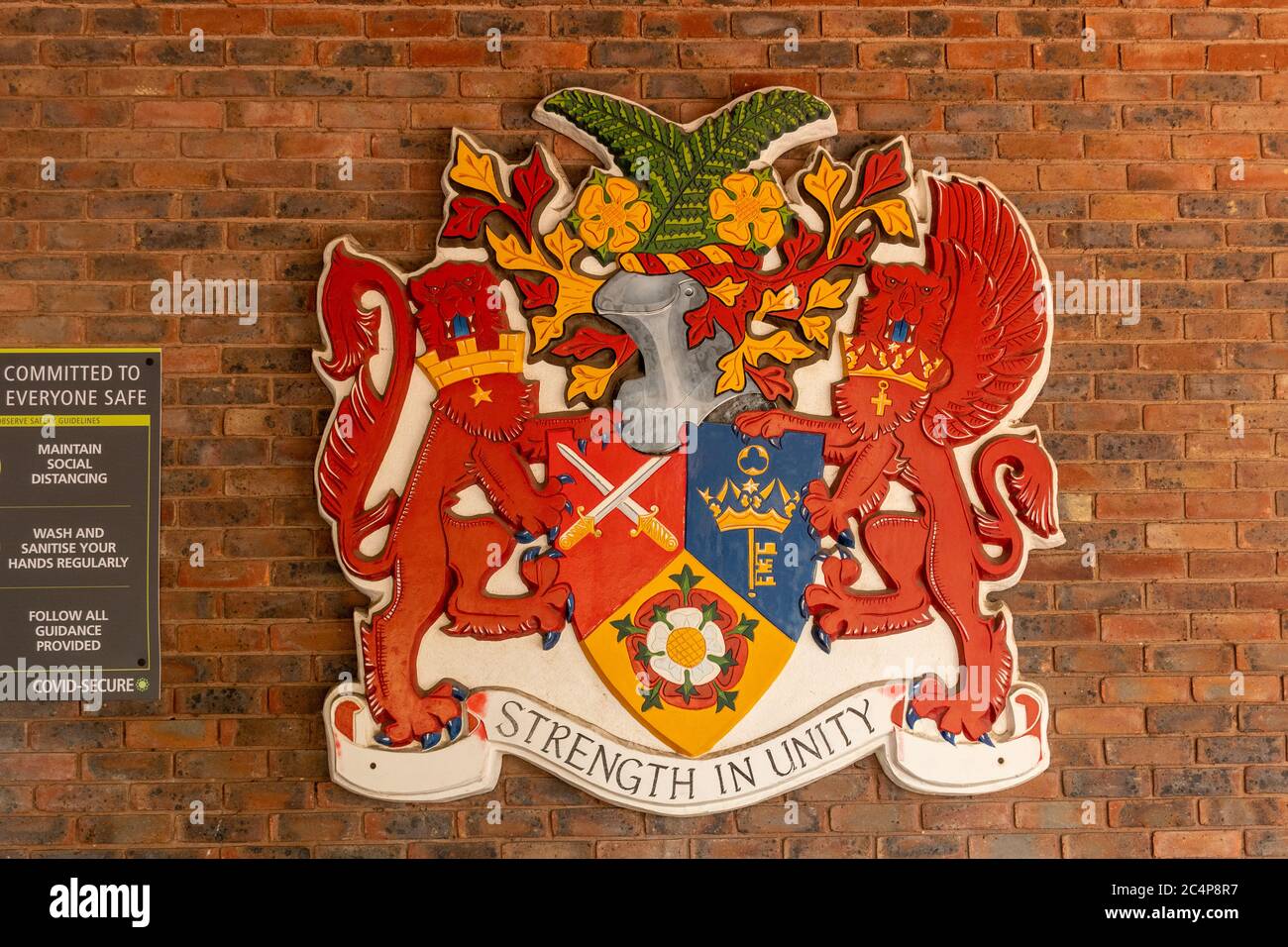 Rushmoor Wappen (Wappen) mit dem Motto Stärke in Einheit auf Rushmoor Ratsbüros, Farnborough, Hampshire, Großbritannien. Heraldik Stockfoto