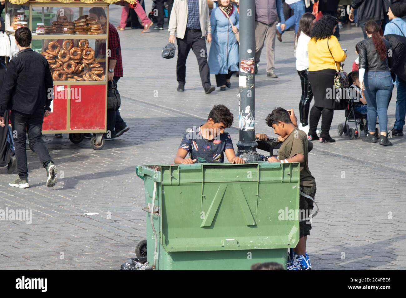 Kinder, die Essen in einem Mülleimer suchen. Die Leute sind da  Stockfotografie - Alamy