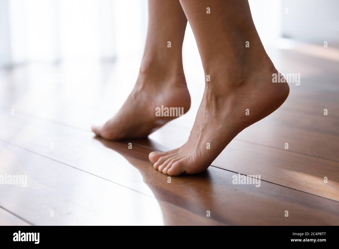 Nahaufnahme der Frau Schritt auf Holzboden barfuß Stockfoto