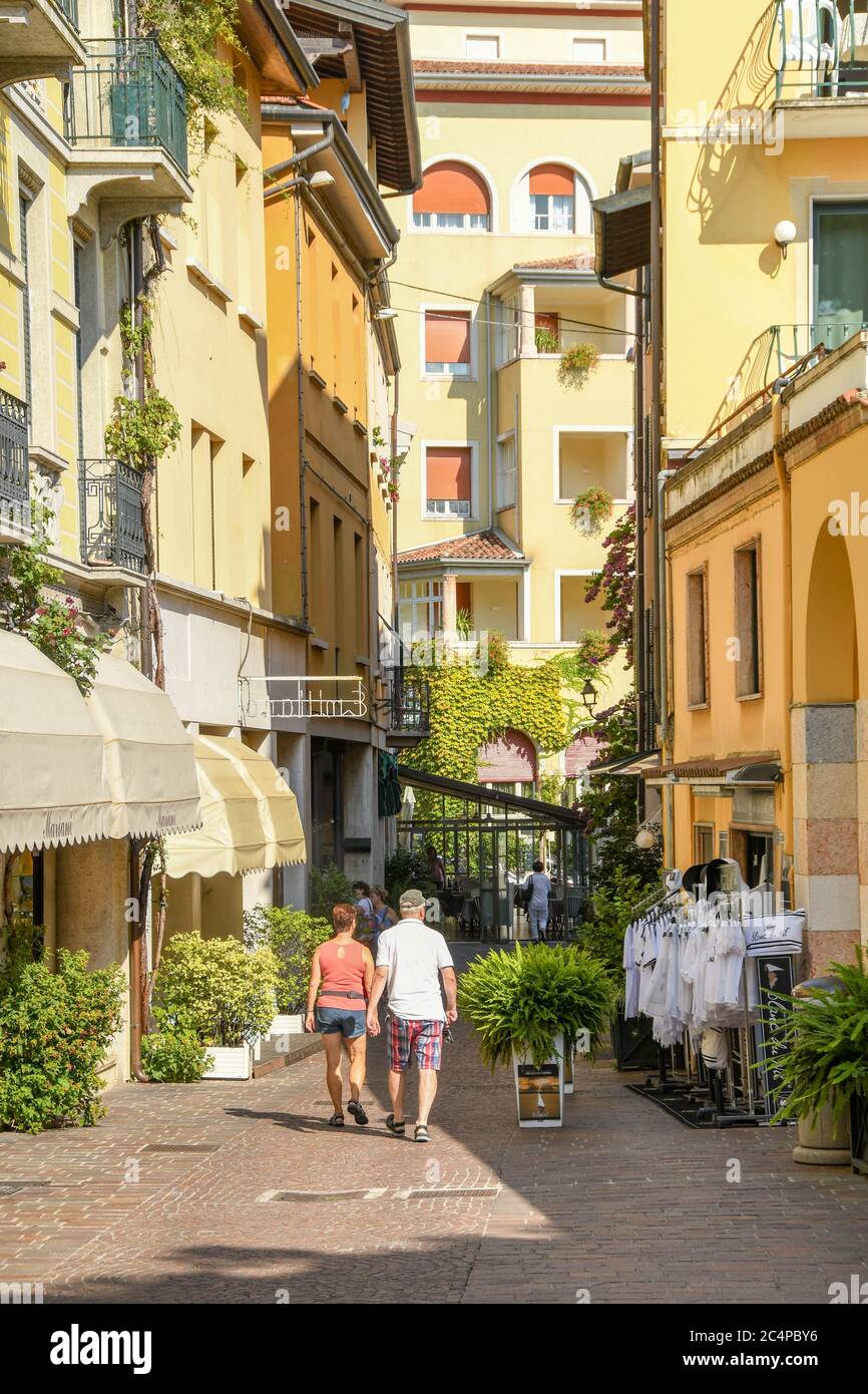 GARDONE RIVIERA, ITALIEN - SEPTEMBER 2018: Zwei Personen gehen eine schmale Straße entlang in Gardone Riviera am Gardasee. Stockfoto