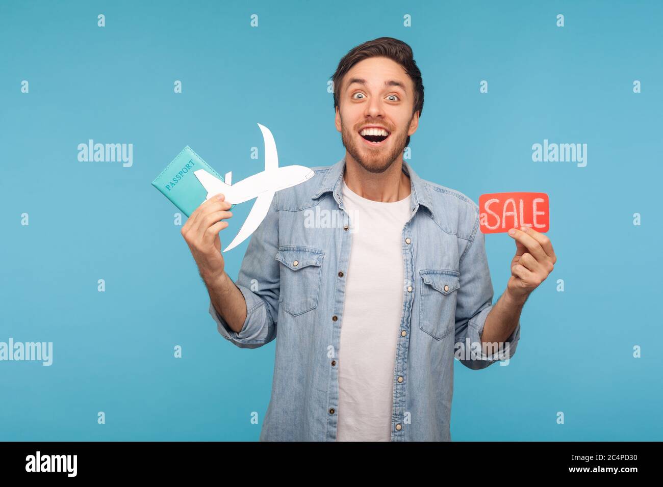 Portrait von stauned glücklich Tourist Mann in Denim-Shirt mit Papier Flugzeug, Pass und Verkauf Wort, Planung Urlaub im Ausland mit günstigen Lufttransport Stockfoto
