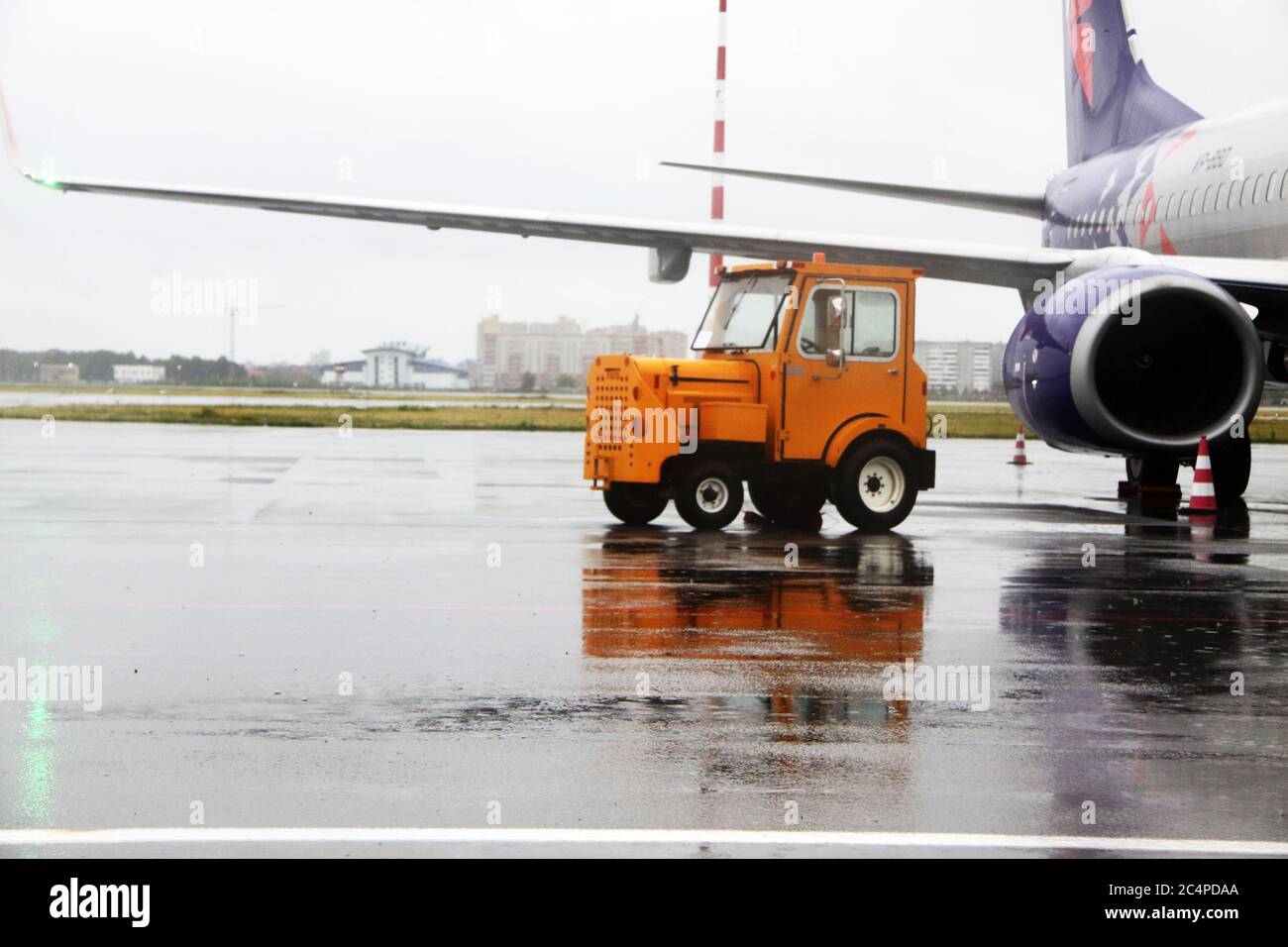 Kompakter Utility-Traktor auf dem Flugplatz eines Flughafens. Bild enthält Kopierraum Stockfoto