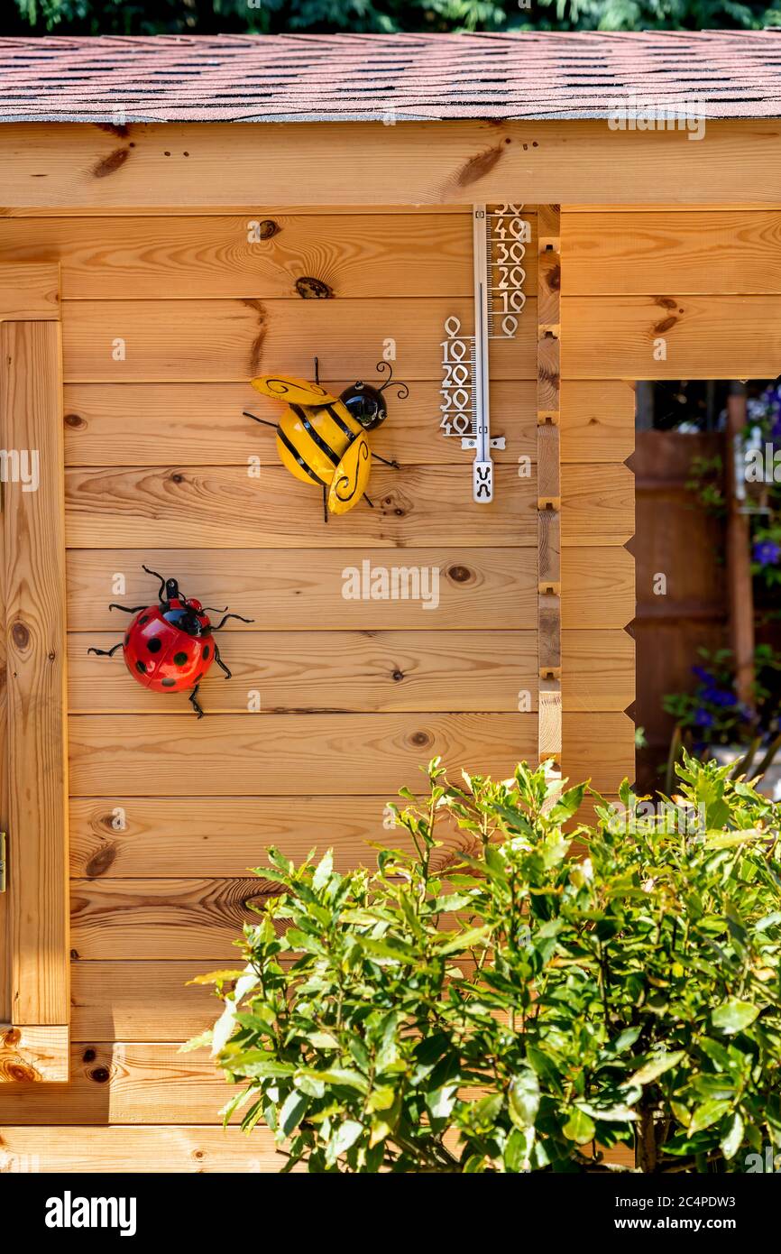 SOMMERHAUS ODER BLOCKHAUS MIT DEKORATIVEN INSEKTEN UND PFLANZEN Stockfoto