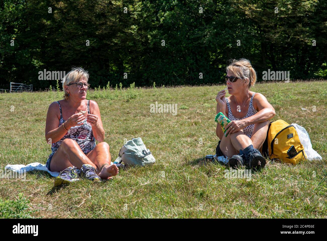 Frauen mittleren Alters sitzen bei einem Picknick in der Landschaft von Kent, während sie spazieren gehen. Stockfoto