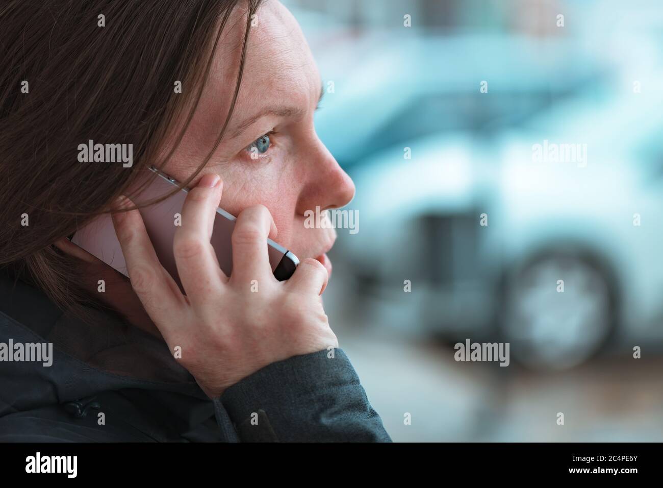 Lässige Frau, die mit dem Handy unterwegs auf der Straße in der modernen urbanen Umgebung kommuniziert, selektive Fokussierung Stockfoto