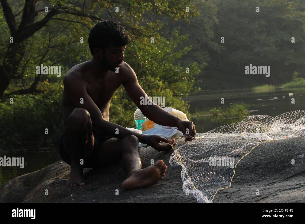 Mann, der ein Fischernetz zusammennäht Stockfoto