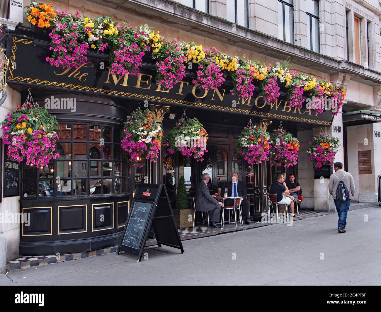 Londoner Pubs haben im Sommer oft Sitzbereiche im Freien, die mit bunten Blumenkörben geschmückt sind. Stockfoto