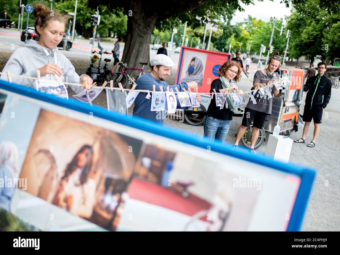 Hannover, Deutschland. Juni 2020. Studierende und wissenschaftliche Mitarbeiter des Studiengangs Fotojournalismus und Dokumentarfotografie der Hochschule für Technik und Kunst Hannover hängen gedruckte Fotos auf einem mobilen Stand auf. Da das Festival aufgrund der Corona-Pandemie nicht wie geplant stattfinden konnte, reisen Studenten an den Festivaltagen mit gedruckten Fotos durch die Stadt und stellen sie an verschiedenen Orten aus. Alle Fotoserien und Multimedia-Geschichten können auch online angesehen werden. Quelle: Hauke-Christian Dittrich/dpa/Alamy Live News Stockfoto