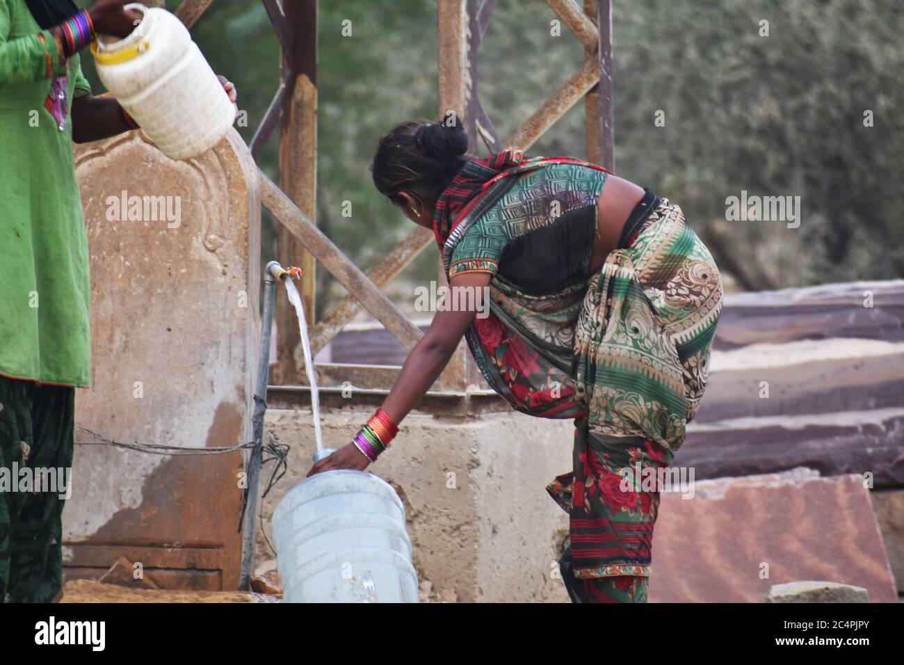 Eine arme Frau, die Wasser am Straßenrand von jaisalmer sammelt Stockfoto