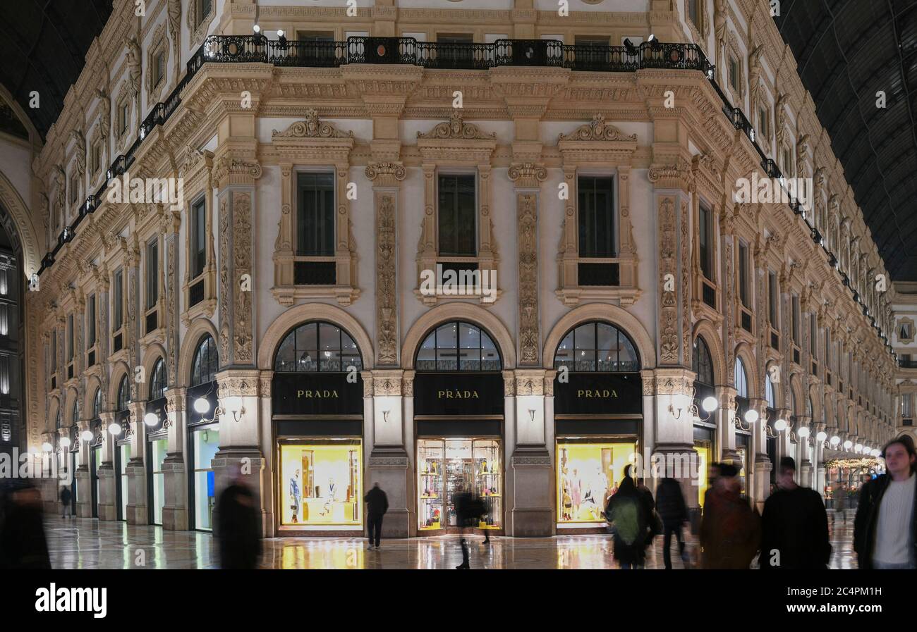 Mailand, Italien - 13. Januar 2020: Menschen, die an der Galleria Vittorio Emanuele II vorbeikommen Prada Vitrinen bei Nacht Stockfoto