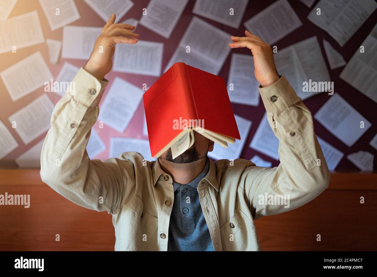 Mann mit einem Buch, das auf den Kopf fällt. Konzept des Erwerbs von Wissen. Kreativität und Lesen. Stockfoto