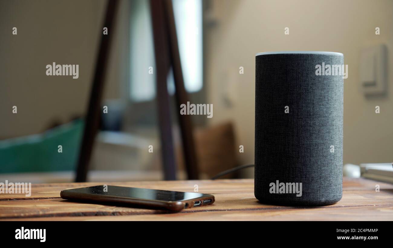 Dunkelgrau Schwarzer Amazon Alexa Echo und Smartphone auf dem Holztisch im  Wohnzimmer Stockfotografie - Alamy