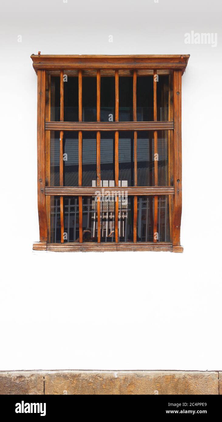 Altes Holzfenster auf weißer Wand mit Steinkante in vertikalem Format Stockfoto