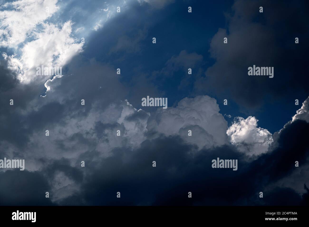 Summer Cumulus Wolken hinterleuchtet bilden eine silberne Auskleidung am Rand der Formation, versteckt den blauen Himmel. 26. Juni 2020 Stockfoto