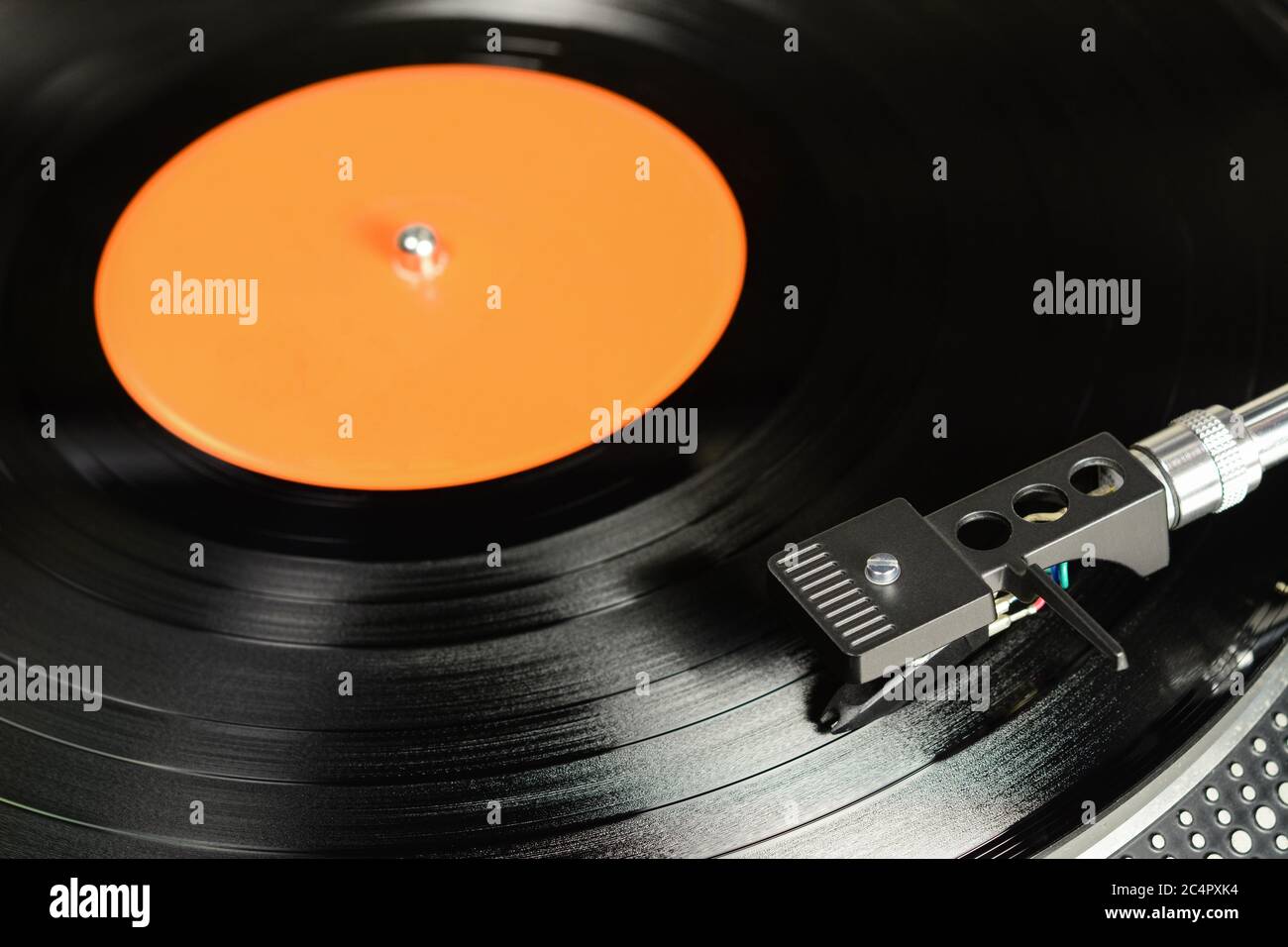 Vinylplatte mit leerem orangenen Label, auf dem Plattenspieler mit audiophiler Kassette gespielt. Stockfoto