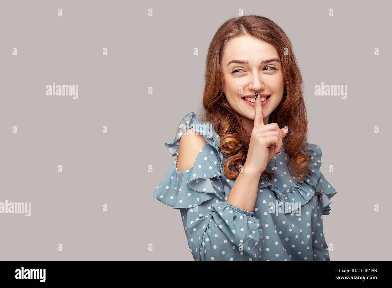 Ah, ruhig bleiben! Schöne glücklich fröhlich brünette Mädchen Rüschen Bluse fragen nach Stille Geheimhaltung mit Finger auf den Lippen, bitte aufhören zu reden, vertraulich ich Stockfoto