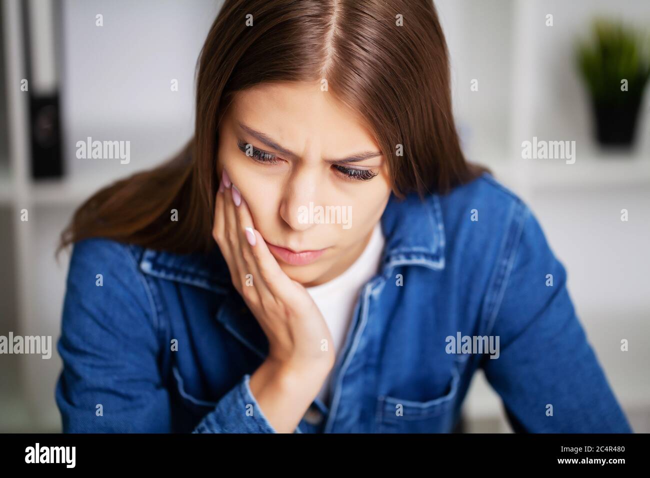 Erschöpfte Frau im Büro, die unter schweren Zahnschmerzen leidet Stockfoto