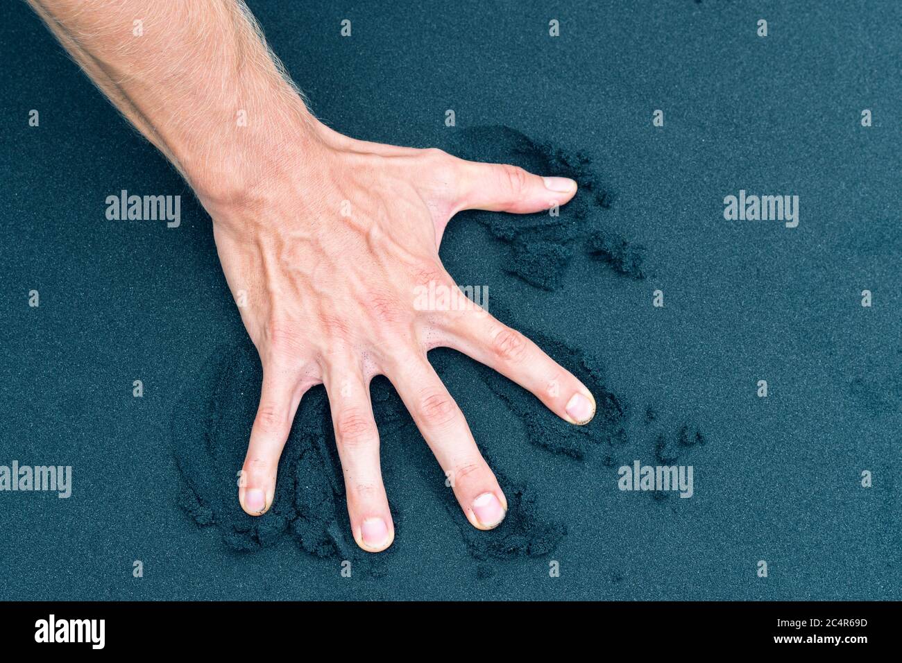 Rechte männliche Hand, die Sand am Strand zurückdrückt Stockfoto