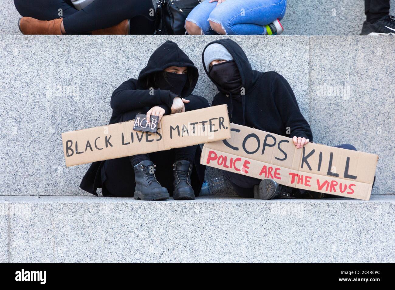 Demonstranten, die unter Nelson-Säule sitzen, Demonstration der Black Lives Matter, Trafalgar Square, London, 20. Juni 2020 Stockfoto