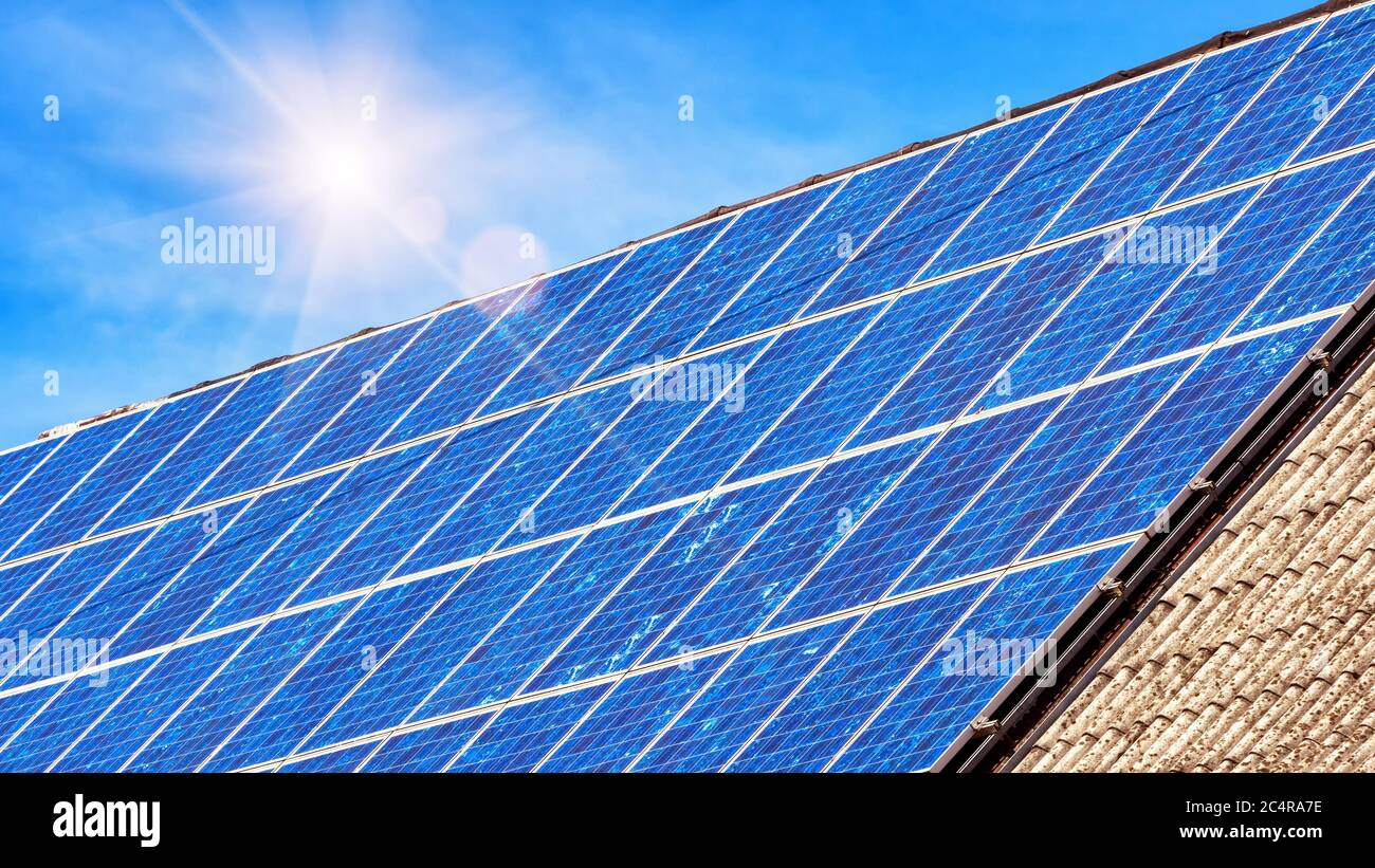 Solarpanel auf Wohnhausdach. Viele blaue Solarzellen auf dem Gebäudetisch für alternative Energie. Photovoltaik Öko-Paneele auf dem Hausdach. Technolo Stockfoto