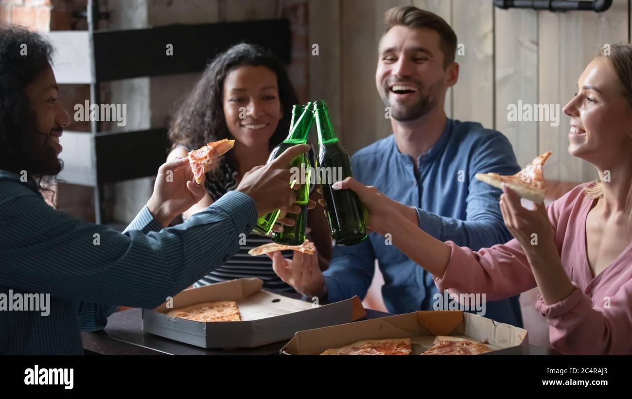 Multirassische Freunde essen Pizza mit Bier klirren feiern Leben Ereignis Stockfoto