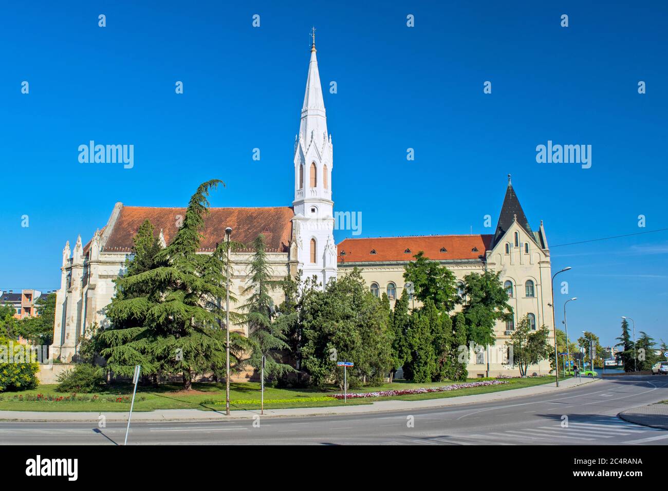 Zrenjanin, Serbien, 27. Juni 2020. Reformierte Kirche und Hof Gebäude in Zrenjanin in den frühen Morgenstunden von der Sonne beleuchtet. Stockfoto