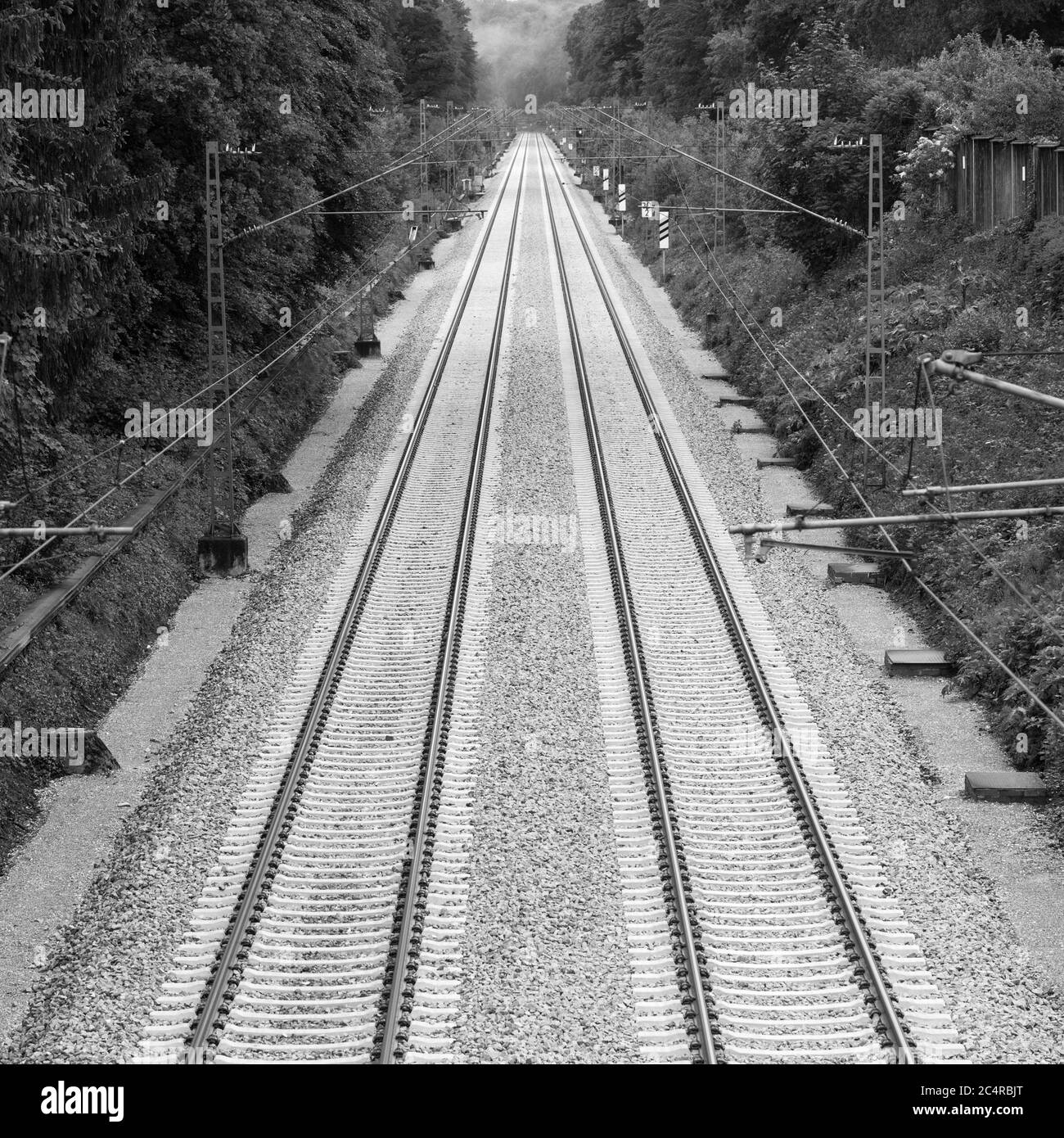 Schwarz-Weiß-Foto von zwei Bahngleisen, die in die Ferne führen. Symbol für Trauer, Verlust und Trauer. Stockfoto