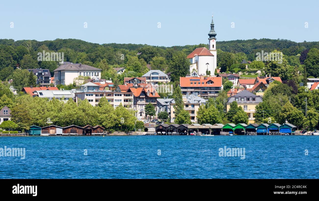 Blick auf die Stadt Starnberg mit dem Starnberger See im Vordergrund. Mit bunten Bootshäusern und Kirche St. Josef. Stockfoto Blick auf die Stadt Starnberg mit dem Starnberger See im Vordergrund. Mit bunten Bootshäusern und Kirche St. Josef. Stockfoto