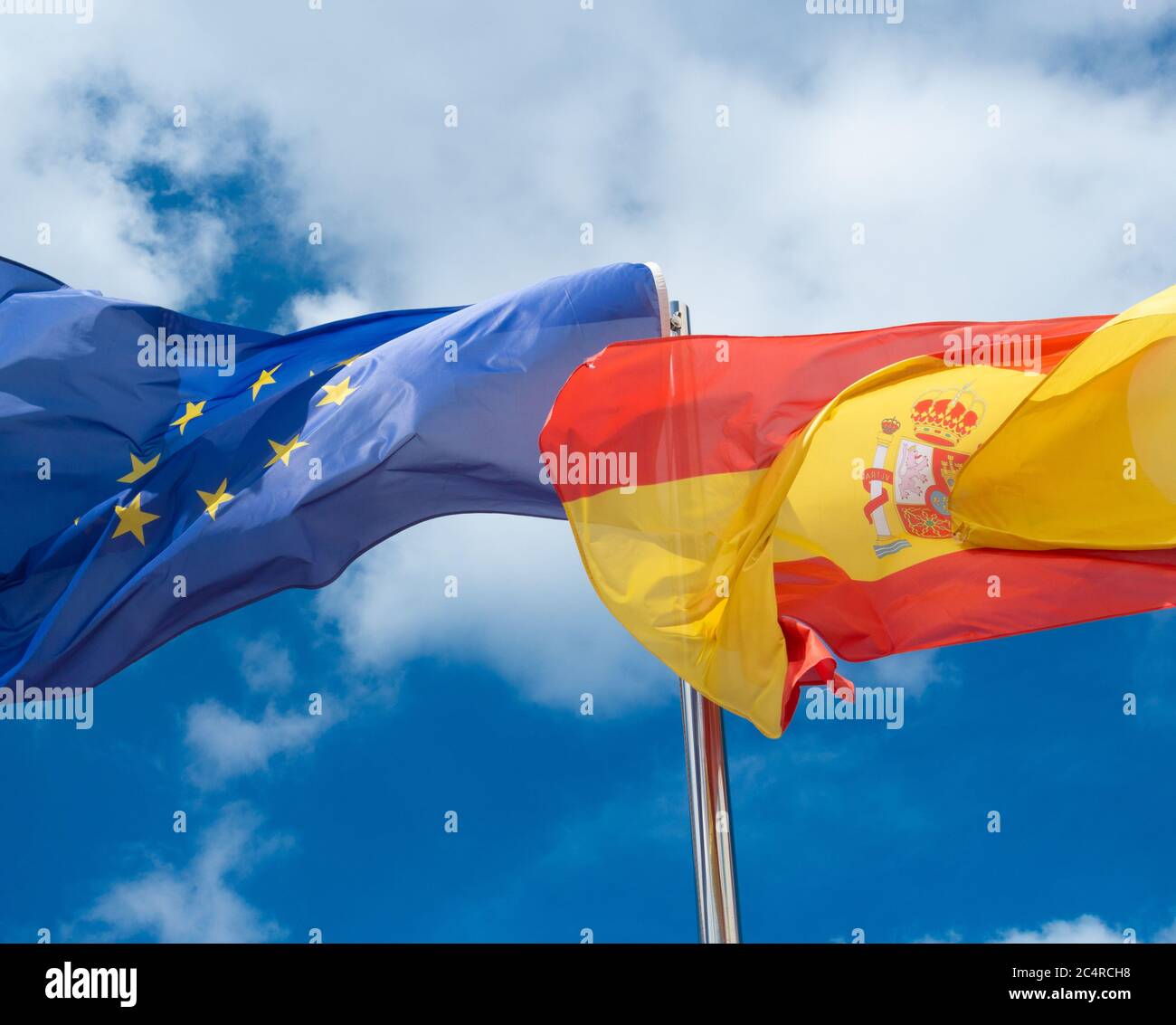 Spanische Flagge und EU-Flaggen gegen blauen Himmel Stockfoto