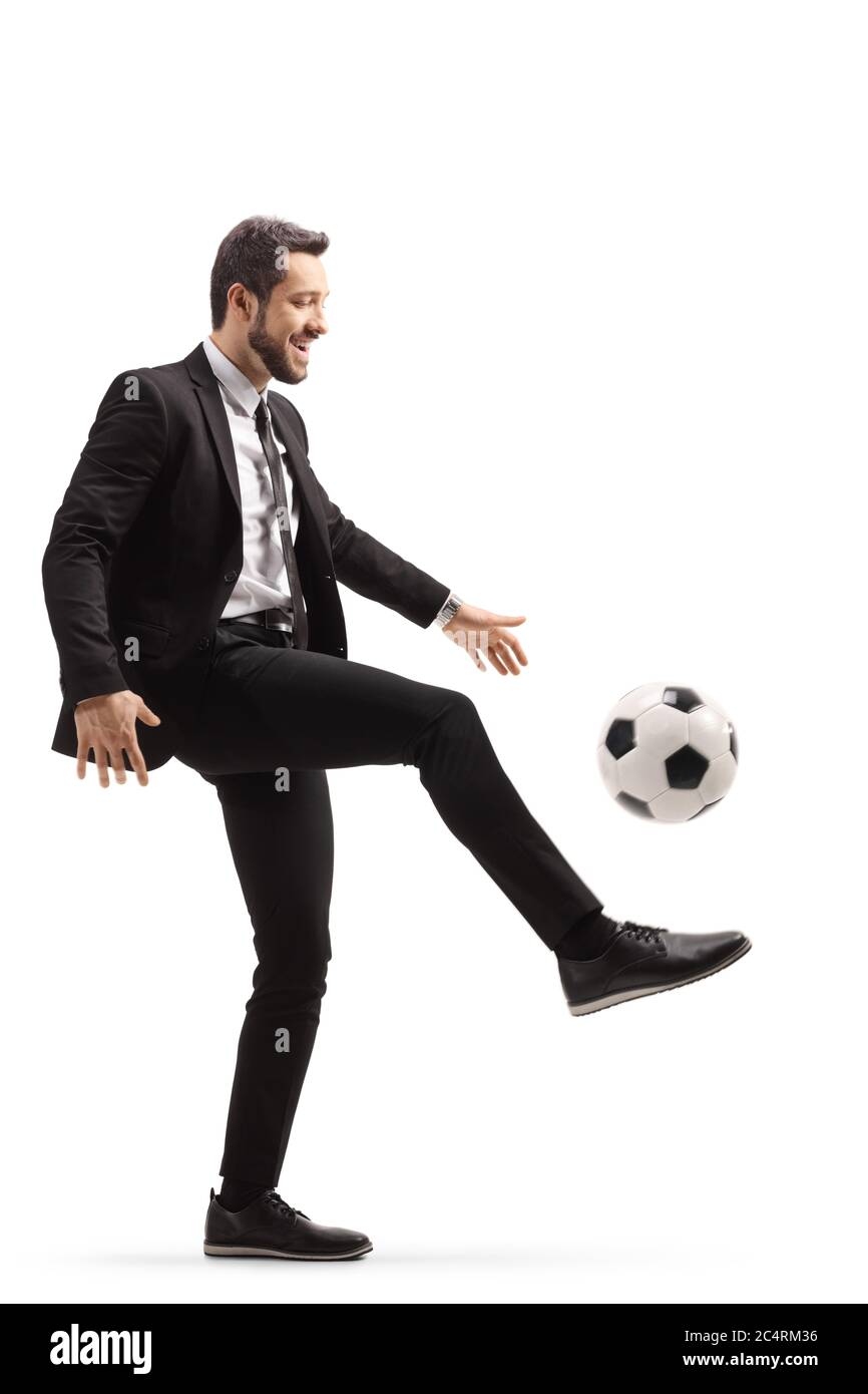 In voller Länge Profilaufnahme eines Geschäftsmannes, der mit einem Fußball auf weißem Hintergrund isoliert spielt Stockfoto
