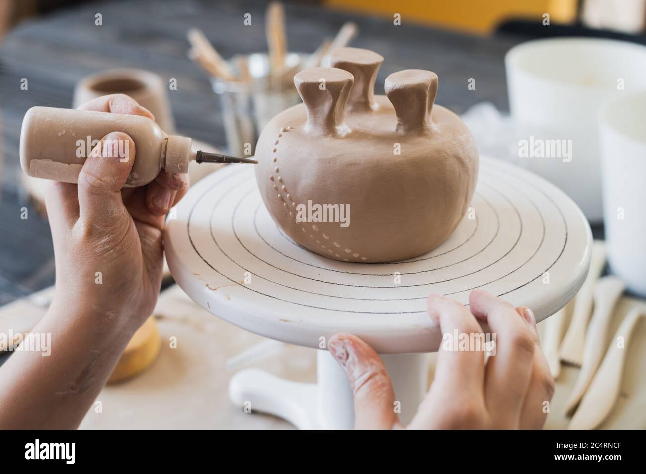Kind in den Prozess der Dekoration der Tonvase. Töpferwerkstatt für Kinder. Stockfoto