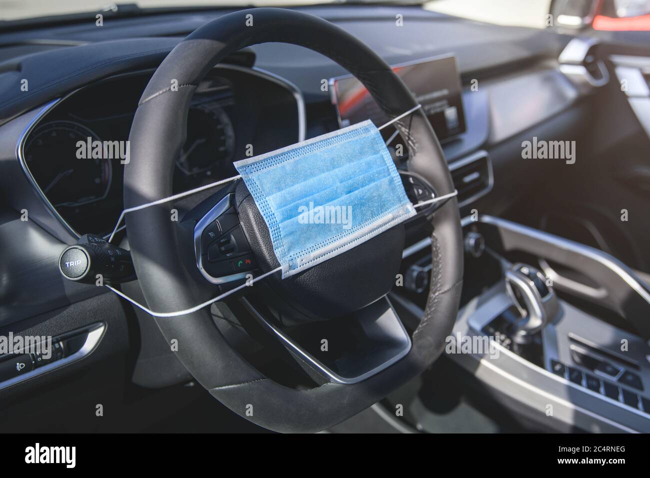 Schutzmaske am Lenkrad eines Autos mit geringer Schärfentiefe Stockfoto