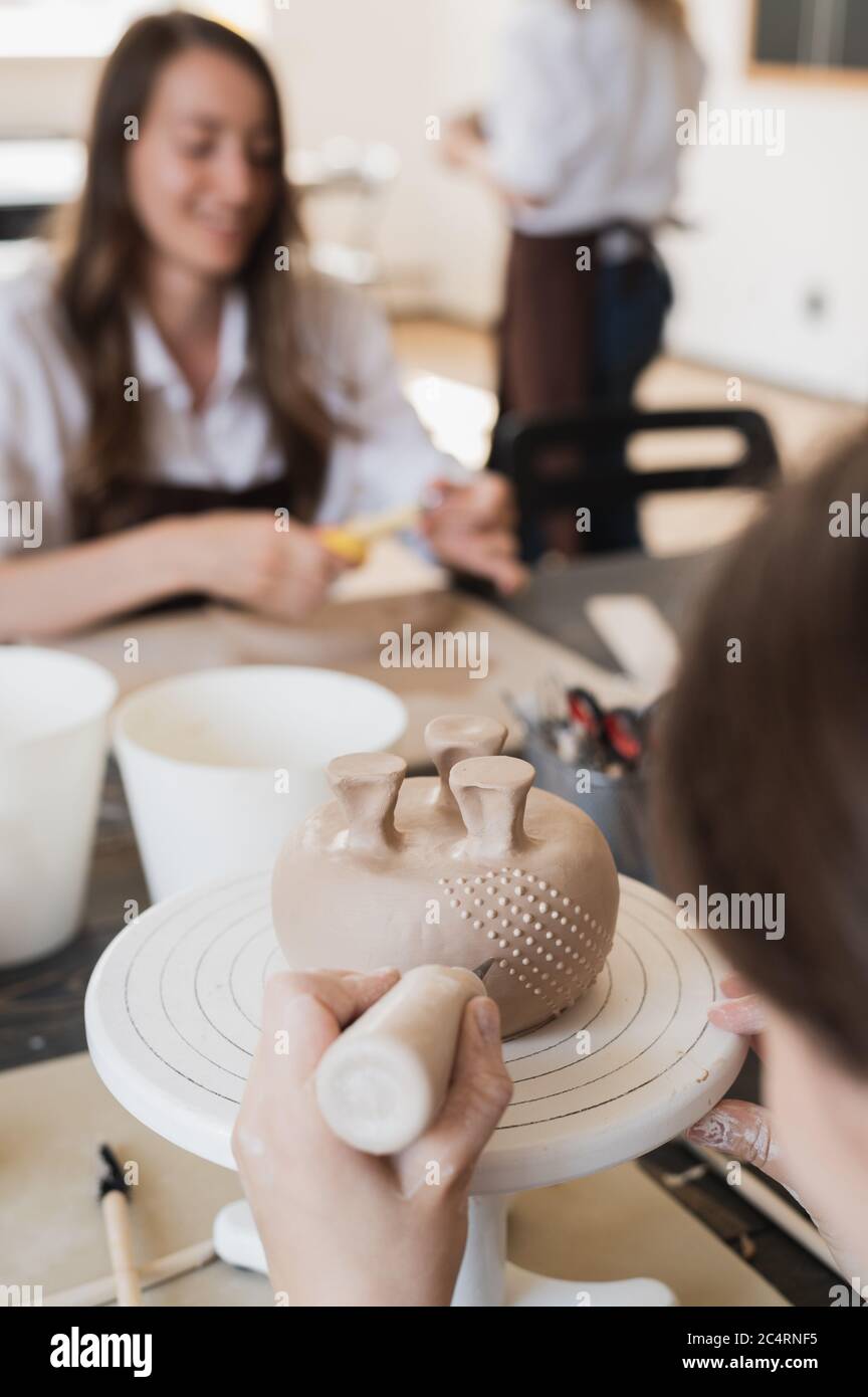 Kind in den Prozess der Dekoration der Tonvase. Töpferwerkstatt für Kinder. Stockfoto