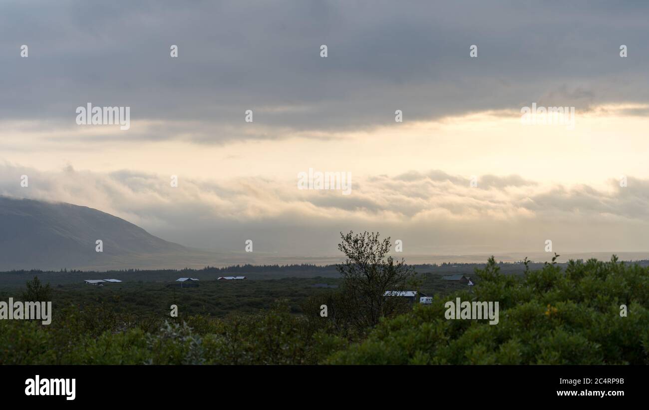 Brechen Sie in den Wolken bei einem Sommeruntergang in Island Stockfoto