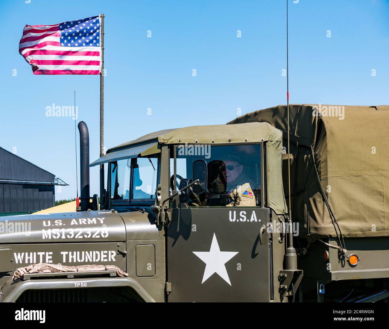 Mann in Militäruniform in US-Armee Fahrzeug mit amerikanischen Stars & Stripes Flagge, Kriegserfahrung Ereignis, East Fortune, East Lothian, Schottland, Großbritannien Stockfoto