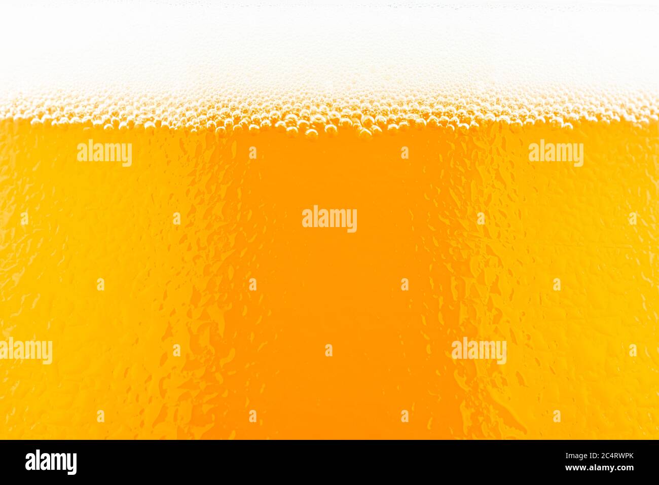 Makroaufnahme von Bier in einem Glas mit sichtbarem Schaum und Wassertropfen. Stockfoto